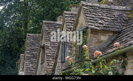 Bibury del villaggio dal tetto di ardesia fila di abbaini poke al di fuori della loro architettura giacobino Foto Stock