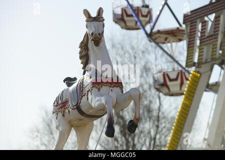 Giostra cavallo in un parco di divertimenti su un cielo blu sullo sfondo Foto Stock