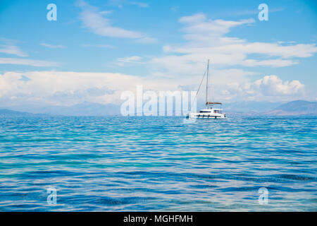 Catamarano in mare blu.bianco barca a vela catamarano sul mare vicino alla spiaggia.barca di lusso vicino alla costa.spazio copia Foto Stock