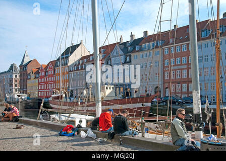 COPENHAGEN, Danimarca - 13 Aprile 2010: persone sedersi sul terrapieno lungo Nyhavn. Foto Stock