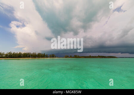 Dark nuvole temporalesche approccio e coprire il cielo blu su un'isola delle Bahamas Foto Stock