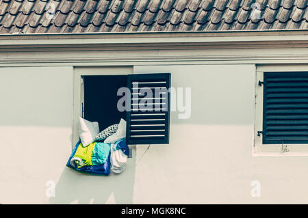 Vecchia casa olandese con una finestra aperta in cui la biancheria da letto si blocca Foto Stock