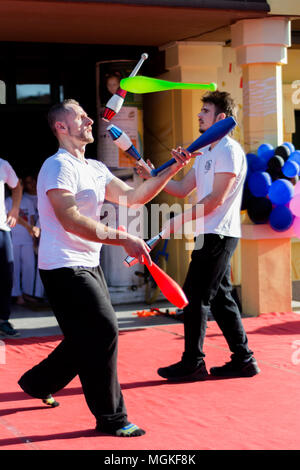 Nis, Serbia - Aprile 27, 2018: giocoliere con bastoni colorati juggling sul palco. Messa a fuoco selettiva Foto Stock