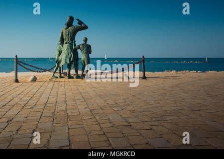 'Spongono dei marinai', una statua di bronzo per artista Quinto Pagliarani che celebra le mogli dei marinai, che si trova a Cesenatico, Italia. Vista posteriore. Foto Stock