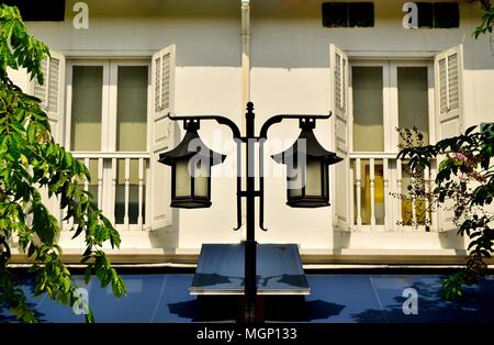 Vintage lampione incorniciata da antichi aperto persiane di legno di un negozio tradizionale casa nel centro cittadino di Singapore Foto Stock