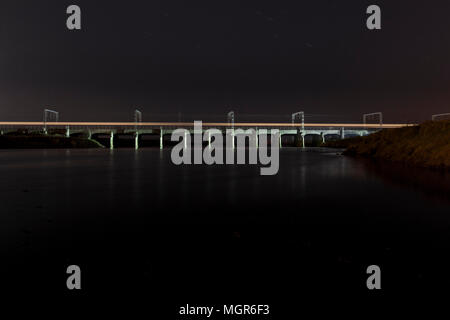 Il viadotto ferroviario a Mossband sulla linea principale della costa occidentale a nord di Carlisle, oltre il fiume Esk con un treno attraversando di notte Foto Stock