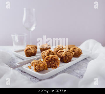 Hot Cross muffin per la Pasqua, illuminate della scena della tabella Foto Stock