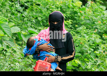 Un rifugiato Rohingya porta il suo bambino attraverso i punti di confine in Ukhia upazila di Cox's Bazar distretto, Bangladesh. Foto Stock