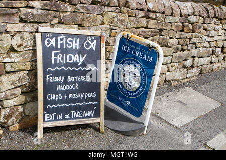 Pesci n' chip shop segno o una scheda sul marciapiede esterno cafe Foto Stock