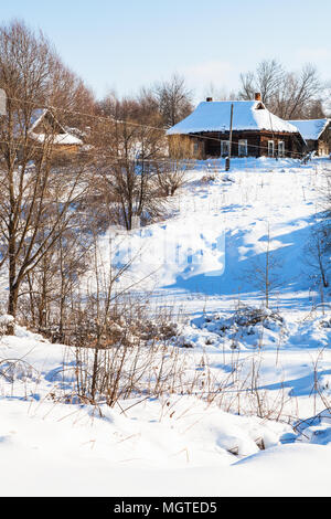 Vista del burrone e piccolo villaggio russo nella soleggiata giornata invernale di Smolensk Regione della Russia Foto Stock