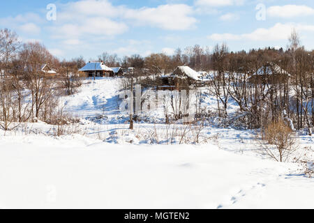 Coperte di neve piccolo villaggio russo nella soleggiata giornata invernale di Smolensk Regione della Russia Foto Stock