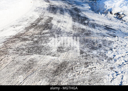 Superficie della neve-cancellato scivolosa strada urbana nella soleggiata giornata invernale Foto Stock