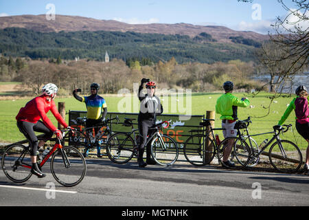 Fort Augustus, Scotland, Regno Unito. Il 29 aprile, 2018. I ciclisti che partecipano all'Etape Loch Ness chiuso il ciclo stradale sportiva a seguito di un 360-grado 66-Mile / 106 km del percorso attorno a Loch Ness, Scozia, in partenza e a Inverness. Questo evento è atteso per attirare 5.600 ciclisti provenienti da tutta la Scozia e il Regno Unito. Migliaia di sterline saranno sollevate dai partecipanti per Macmillan Cancer Support, l'evento ufficiale di carità. Questa immagine mostra i partecipanti di fermarsi per scattare foto a metà strada vicino a Fort Augustus. Cliff verde/Alamy Live News Foto Stock