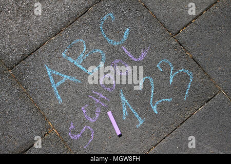 Scuola, ABC lettere e 123 sospiro scritto con gessi colorati su un marciapiede. Disegno torna a scuola su un asfalto e concetto di vacanza. Istruzione conc Foto Stock