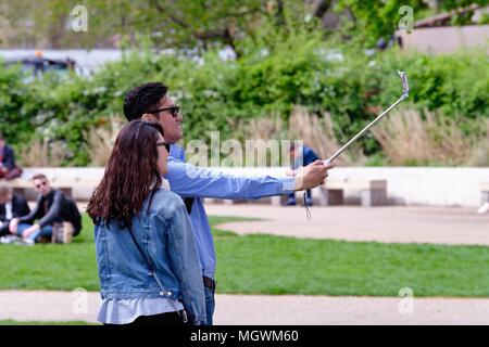 Un asiatico giovane tenendo selfies nella torre di Victoria Gardens Westminster Londra Inghilterra REGNO UNITO Foto Stock