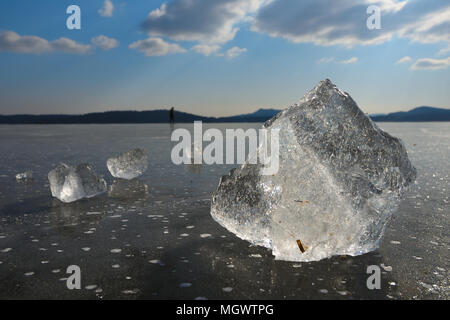 Il ghiaccio naturale pista di pattinaggio all'aperto pezzi rotti di ghiaccio splendente. Le bolle di aria nello spessore del ghiaccio. Foto Stock