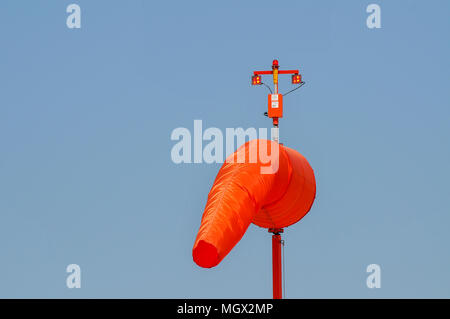 Orange manica a vento su un cielo blu sullo sfondo fotografato in un aeroporto di Haifa, Israele Foto Stock