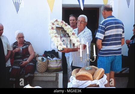 Un uomo porta l'icona durante la festa di San Nicola, Samos, Grecia. Il giorno di San Nicolao è il 6 dicembre ma questo beachside la chiesa celebra in estate. Foto Stock