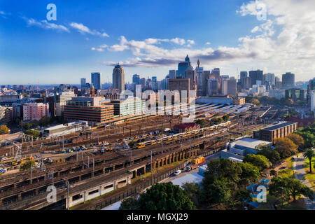 Sydney stazione ferroviaria centrale con molte ferrovie provenienti da treni intercity e piattaforme locali di fronte alto ufficio torri in una giornata di sole. Foto Stock