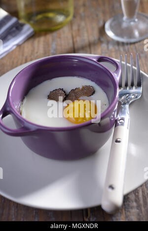 Uovo cotto al forno con fette di tartufo in una cocotte Foto Stock