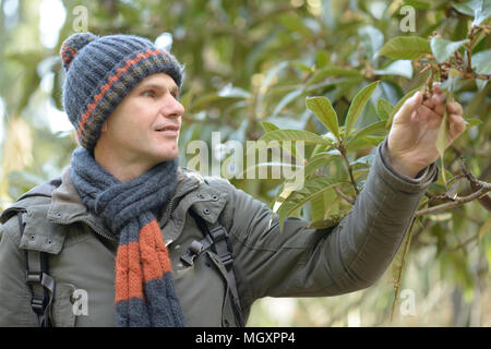 L'uomo indossare indumenti a maglia sfondo turchese. Accessori Invernali  concetto. Inverno moda vestiti a maglia. Gli accessori a maglia come  cappello e sciarpa. Uomo in berretto lavorato a maglia e sciarpa invernale