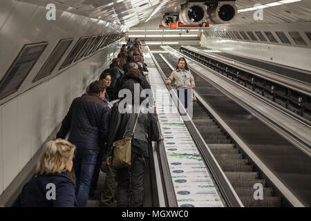 BUDAPEST, Ungheria - 7 Aprile 2018: persone salendo da una stazione della metropolitana di Budapest su una scala mobile nelle ore di punta, scale vuoto può essere visto sul rig Foto Stock