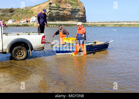 STAITHES, Inghilterra - 21 aprile: Staithes pescatori il caricamento delle catture di appena catturati aragosta sul carrello. In Staithes, Inghilterra. Il 21 aprile 2018. Foto Stock