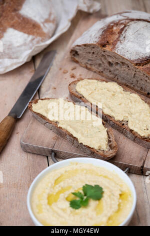 Pane di pasta acida e il farro pane di pasta acida con fatti in casa hummus su un pane a bordo. Regno Unito. Regno Unito
