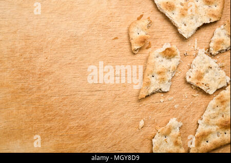 Rotto e cracker sbriciolati su sfondo di legno. Foto Stock
