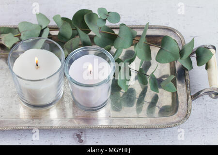 Eco naturale home decor con foglie verdi e candele accese sul tavolo Foto Stock