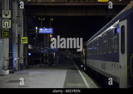 BUDAPEST, UNGHERIA - Aprile 8, 2018: piattaforma della Budapest Nyugati palyaudvar stazione ferroviaria di notte con una tarda sera treno pronto per la partenza Foto Stock