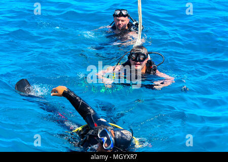 Sharm el-Sheikh, Egitto - Marzo 14, 2018. I subacquei in chiaro e turchese in immersione in bellissimi coralli pesci colorati. La maestra insegna la stu Foto Stock