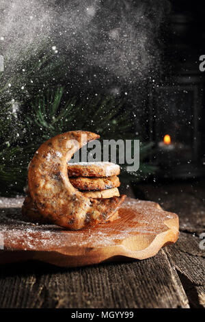 I cookie nella forma di una mezzaluna con pezzetti di cioccolato sono spolverati con zucchero a velo Foto Stock