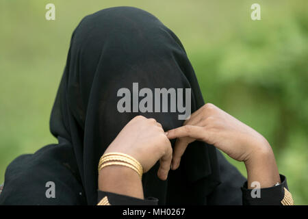 Una donna Rohingya attende da una strada a Ukhia dopo aver immesso il Bangladesh non custodito attraverso i punti di confine. Cox's Bazar, Bangladesh Foto Stock