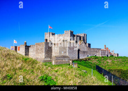 Il castello di Dover, Inghilterra. Vista dall'esterno la parete del castello del bastione interno di mura e di torri con la grande torre, mantenere. Union Jack flag battenti. Foto Stock