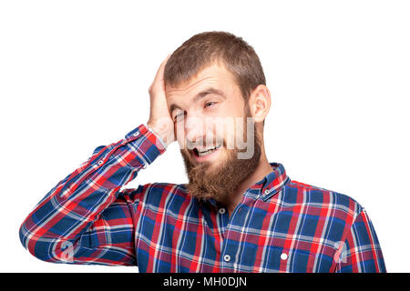 Un giovane uomo barbuto in un plaid shirt sta vivendo un fastidioso errore o omissione. Ritratto emotivo su uno sfondo bianco. Foto Stock