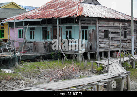 Una scarsa manutenzione casa civile con passerella in legno a Crab Island, un famoso villaggio di pescatori in Malaysia. Foto Stock