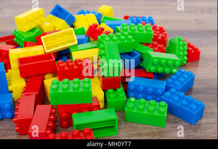 Variopinto edificio giocattolo blocchi su di uno sfondo di legno. Foto Stock