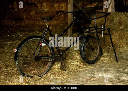 Periodo di puntelli da epoca passata - bicicletta vintage in piedi nel fienile. Foto Stock