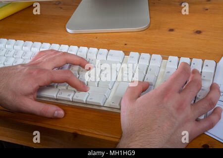 Un giovane uomo con black tshirt lavora sul computer Foto Stock