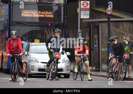 Un ciclista attende al bivio sulla Blackfrairs Bridge Road in sella a una moto di Santander in centro a Londra durante la mattina ora di punta Foto Stock