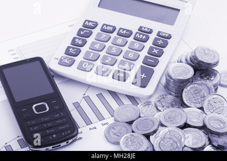 Una calcolatrice seduti su alcuni grafici etichettati risparmi e fondi con alcune nuove (post 2016) pound monete. Foto Stock
