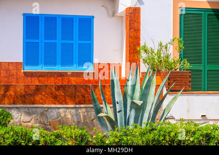 La facciata della tipica casa colorata nel piccolo villaggio sulla costa dell'isola di Maiorca vicino a Cala Ratjada, Spagna Foto Stock