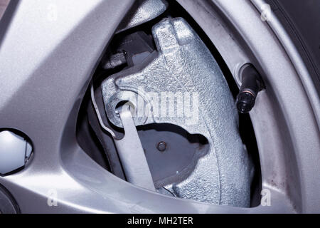 La ruota in alluminio di una vettura moderna dove è possibile vedere i pattini del freno a disco. Foto Stock