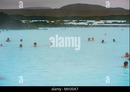 I turisti ed i visitatori godere di energia geotermica all'aperto piscina a laguna blu, Reykjavik, Islanda Foto Stock