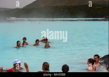 I turisti ed i visitatori godere di energia geotermica all'aperto piscina a laguna blu, Reykjavik, Islanda Foto Stock