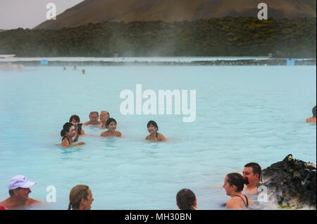 I turisti ed i visitatori godere di energia geotermica all'aperto piscina a laguna blu, Reykjavik, Islanda Foto Stock