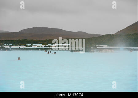 I turisti ed i visitatori godere di energia geotermica all'aperto piscina a laguna blu, Reykjavik, Islanda Foto Stock