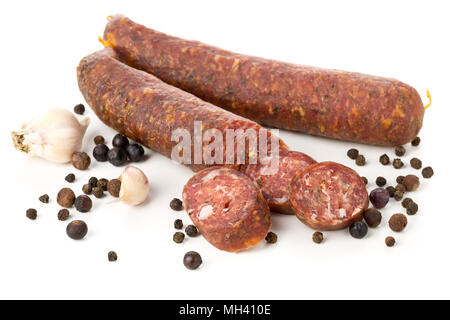 Il tedesco specialità salami hard indurito tutta la salsiccia e affettato con spezie su sfondo bianco Foto Stock