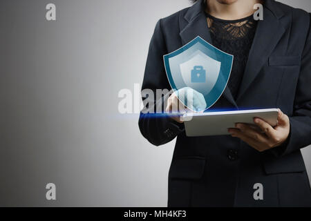 Imprenditrici premere su smart phant e schermo di computer con protezione del concetto di logo Foto Stock